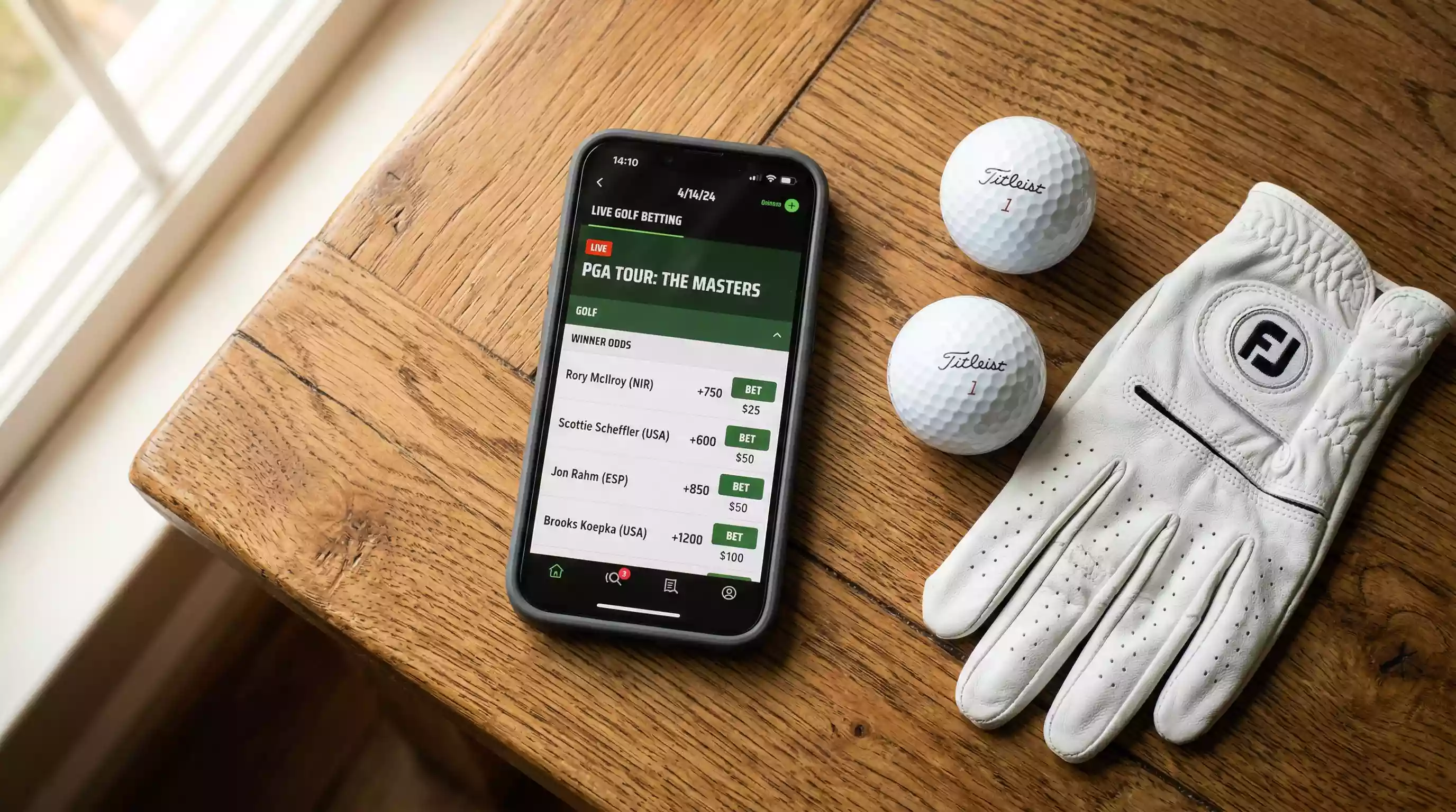 Smartphone zeigt Golf-Wettquoten neben Golfbällen auf dem Tisch