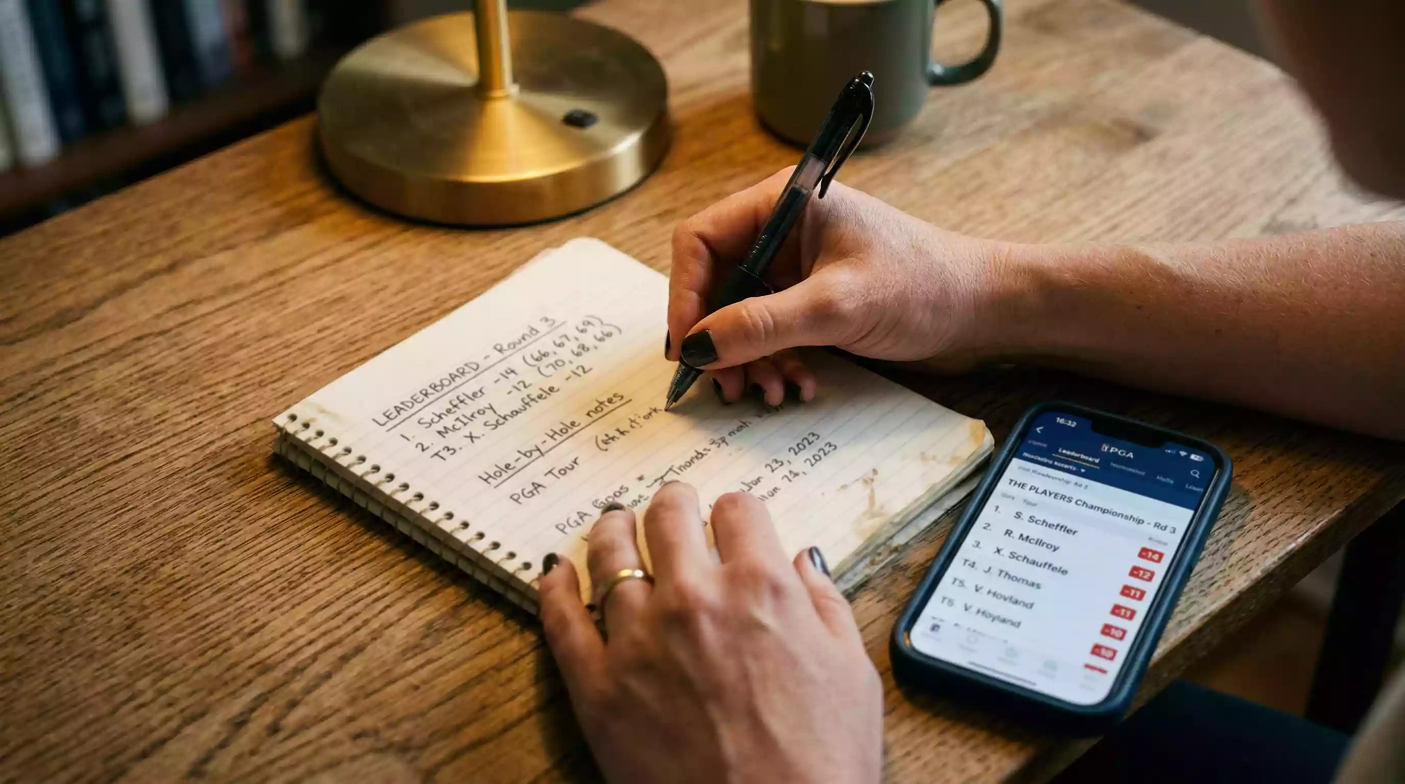 Person analysiert Golfturnier-Ergebnisse auf einem Notizblock